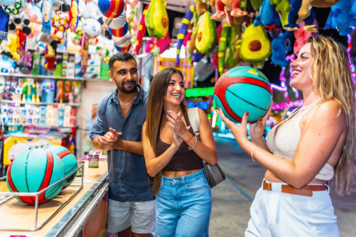 friends-playing-ball-toss-game-at-amusement-park-2025-07-28-19-45-24-utc