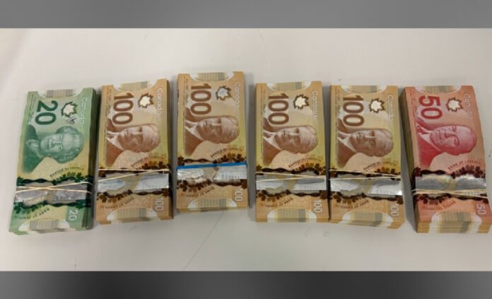 Canadian_Currency _Seized Photograph showing bundles of seized Canadian cash, including $20, $50, and $100 bills, stacked and secured with bands, displayed as police evident