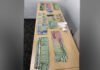 Barrie Police charged two after cocaine, cash found in traffic stop A table displaying seized evidence, including multiple stacks of Canadian currency in various denominations arranged in rows, alongside several small plastic bags containing a white powder believed to be drugs, photographed as part of a police seizure.