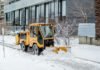 Toronto enforces snow route parking prohibitions during major winter storm yellow snowplow clears snow along a residential sidewalk during a winter storm.