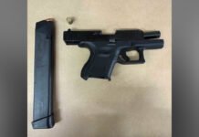 Two Toronto residents charged after loaded handgun seized in Scarborough A black handgun on a light surface with a separate extended magazine placed beside it.
