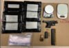 Two charged after Toronto police seize loaded handgun, drugs in Brampton raids Items seized by police laid out on a table including several black plastic-wrapped packages, a small handgun, ammunition magazines and loose rounds, a wristwatch, electronic components, a roll of tape or container, and a small digital scale.