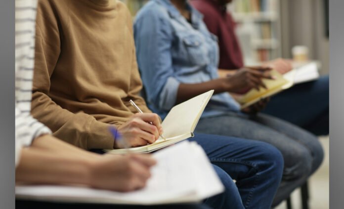 students sitting and writing in notebook