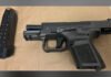 28-year-old faces multiple firearm charges following Toronto Police raid semi-automatic handgun placed on a flat surface with a detached magazine containing ammunition beside it.