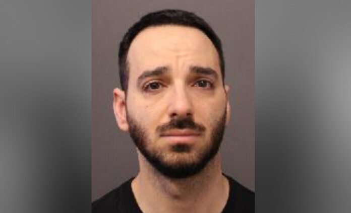 police released headshot image of a man with short dark hair and a trimmed beard, looking straight at the camera with a neutral expression against a plain background.