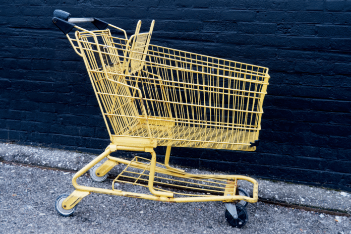 an-empty-yellow-shopping-cart-by-a-black-brick-wal-2026-01-11-09-02-43-utc