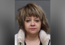 Woman wanted after 12 retail theft incidents across Toronto A close-up portrait of a middle-aged woman with short, layered light brown hair and bangs. She has a neutral expression and is facing the camera directly. She appears to be wearing a light-coloured jacket with a soft collar over a darker top, set against a plain background.