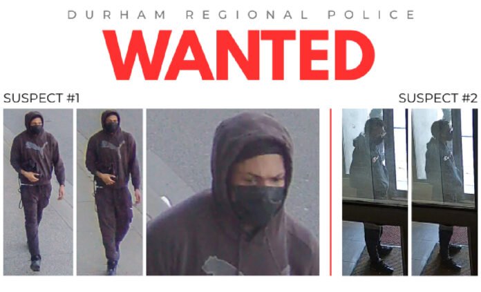 A Durham Regional Police “WANTED” poster displaying surveillance images of two suspects. Suspect #1 is shown walking while wearing a dark hoodie with a Puma logo, dark pants, and a black face covering. Suspect #2 appears in separate images wearing a dark hooded jacket and standing inside a building entrance area.